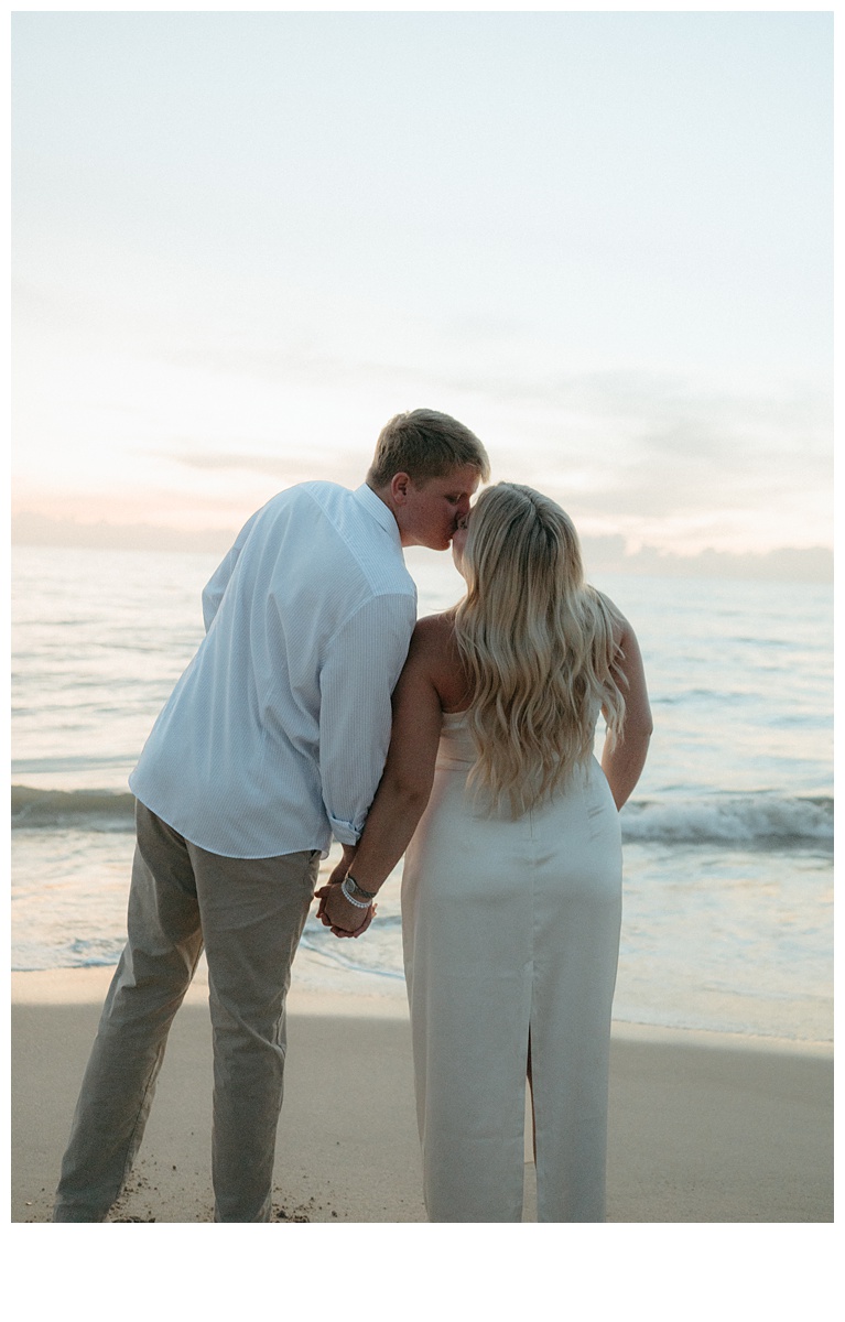 bride and groom facing the sunrise and kissing