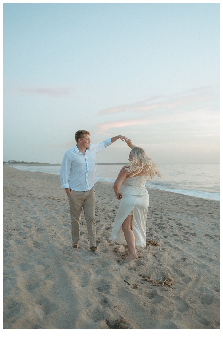 groom gives bride a twirl on the beach at sunrise in florida