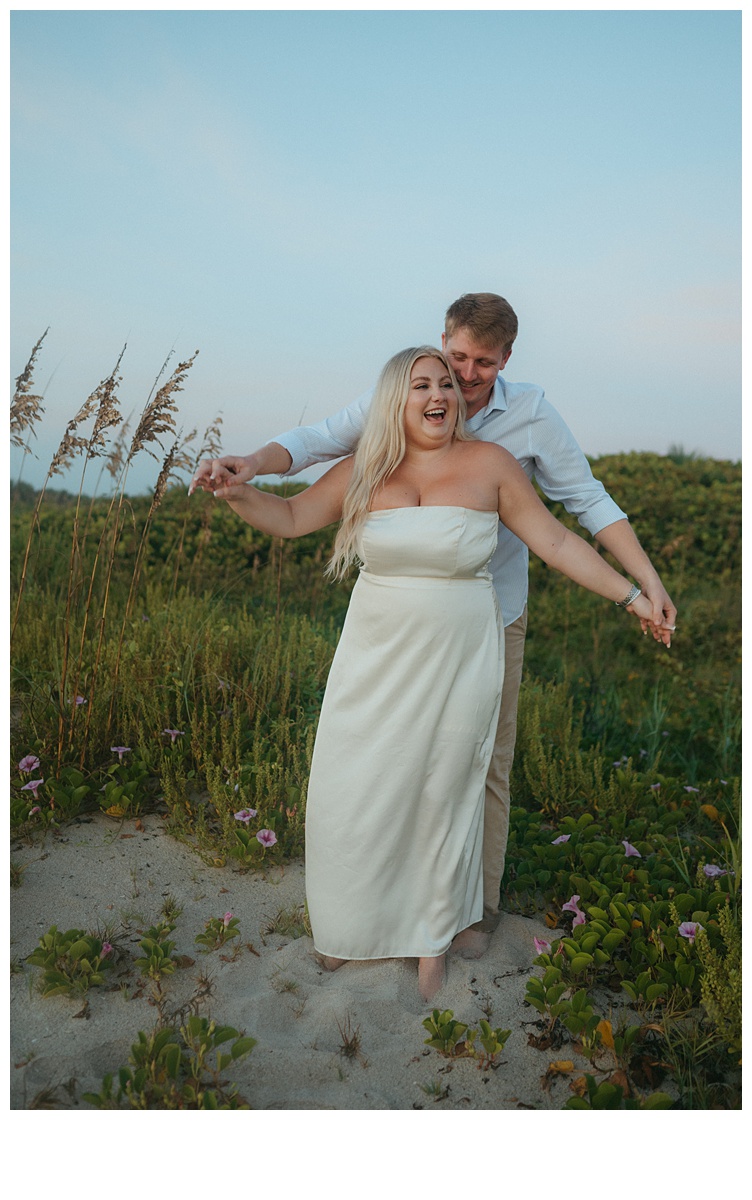 bride and groom having fun and laughing while on a berm after florida beach elopement