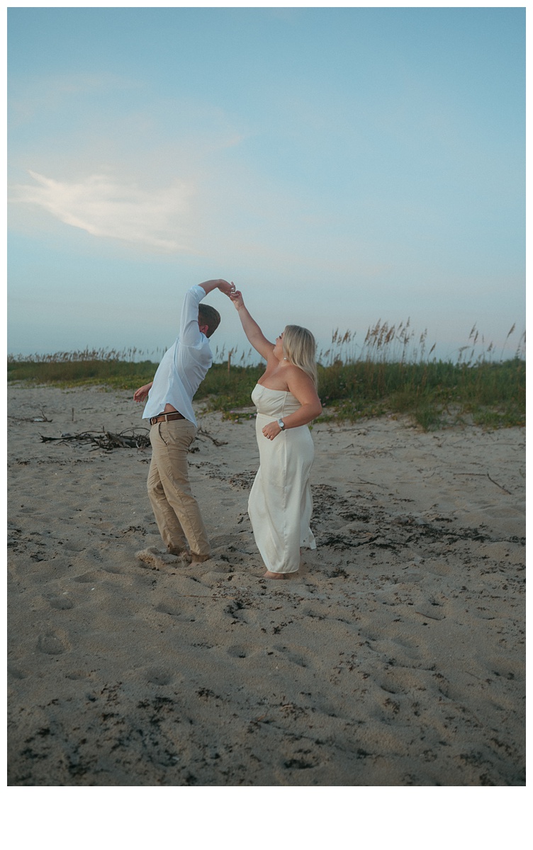 bride giving groom a twirl on the beach at sunrise