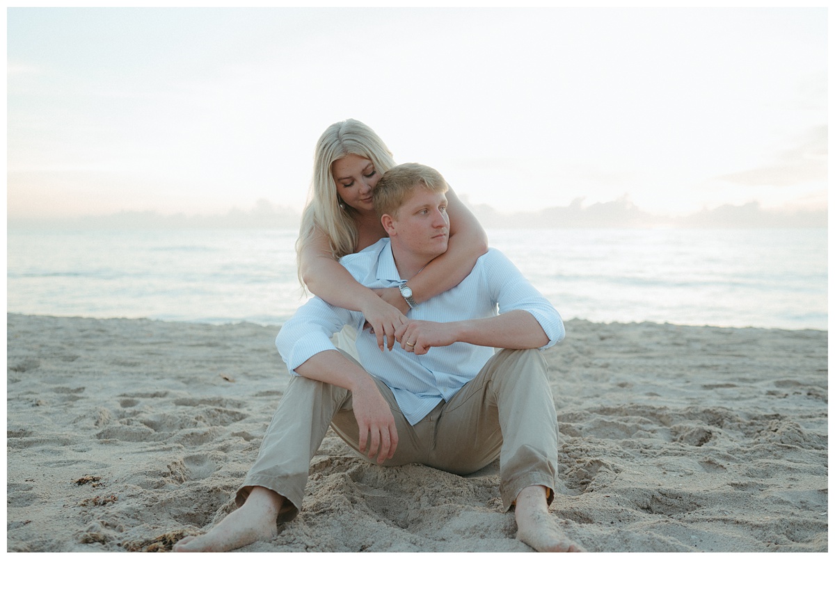 bride leaning over groom while sitting at the beeach after florida beach elopement