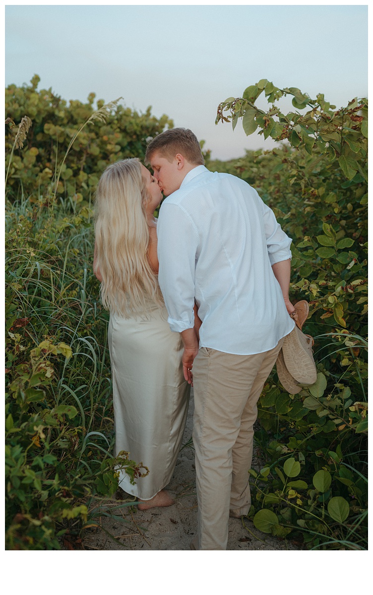 couple kissing walking back from their beach elopement