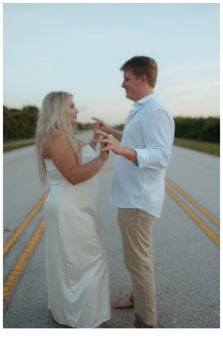 couple posing and holding hands on road