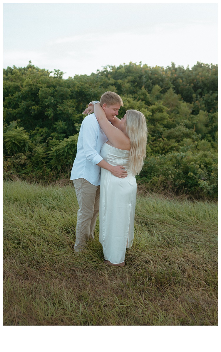 bride and groom hugging in grassy area by sebastian inlet beach