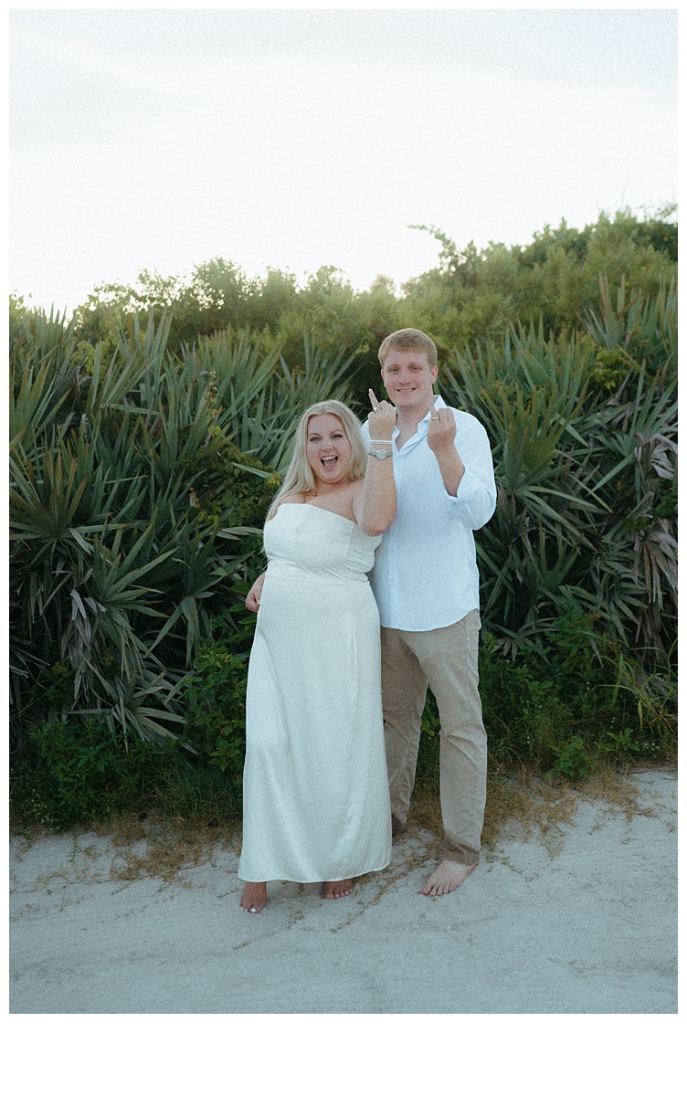 fun couple showing off wedding bands after their elopement