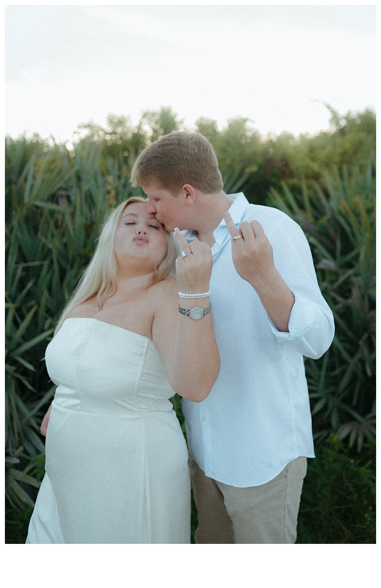 fun couple showing off wedding bands after their elopement