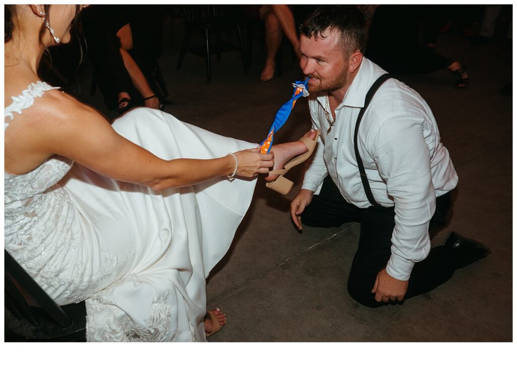 garter removal from groom during reception