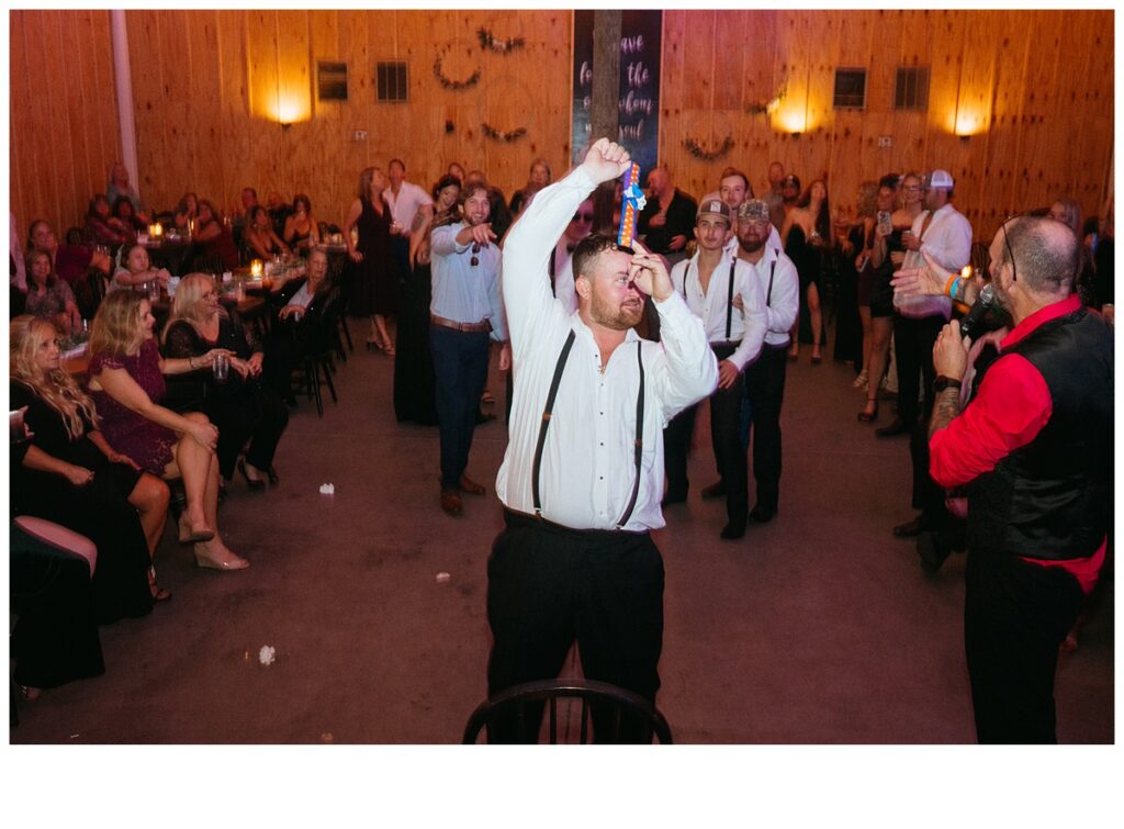 groom tossing garter during reception