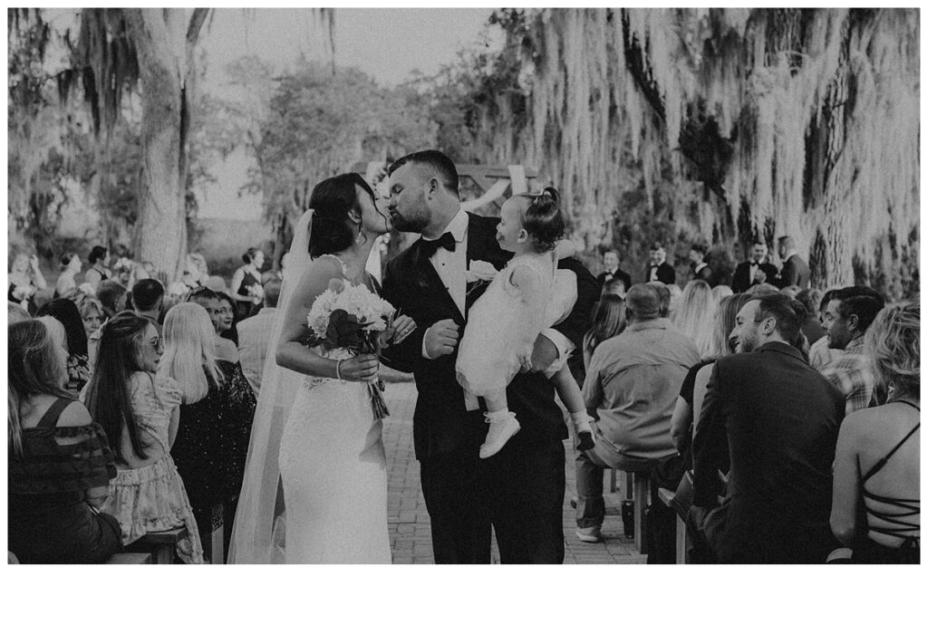 black and white end of aisle kiss for bride aqnd groom at black willow ranch mims