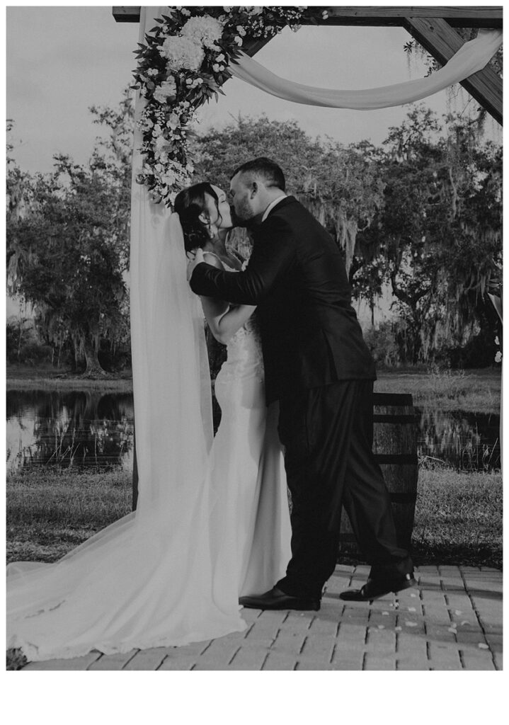 black and white bride and groom kissing at altar