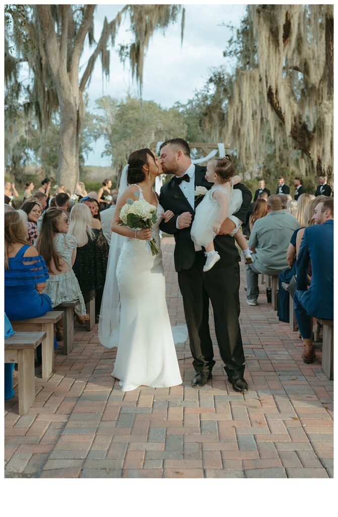 black and white end of aisle kiss for bride and groom 