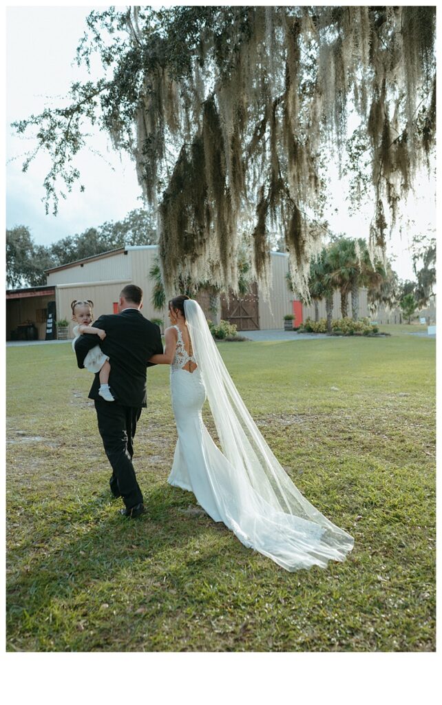 bride and groom walking out of ceremony with daughter