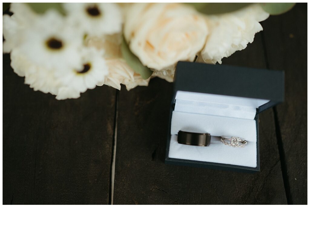 detail photo of bride and groom rings with flowers