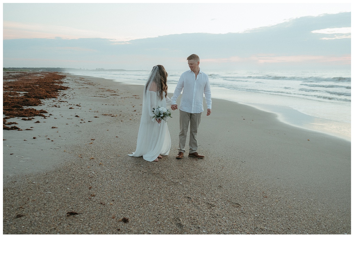 bride and groom walking along beach