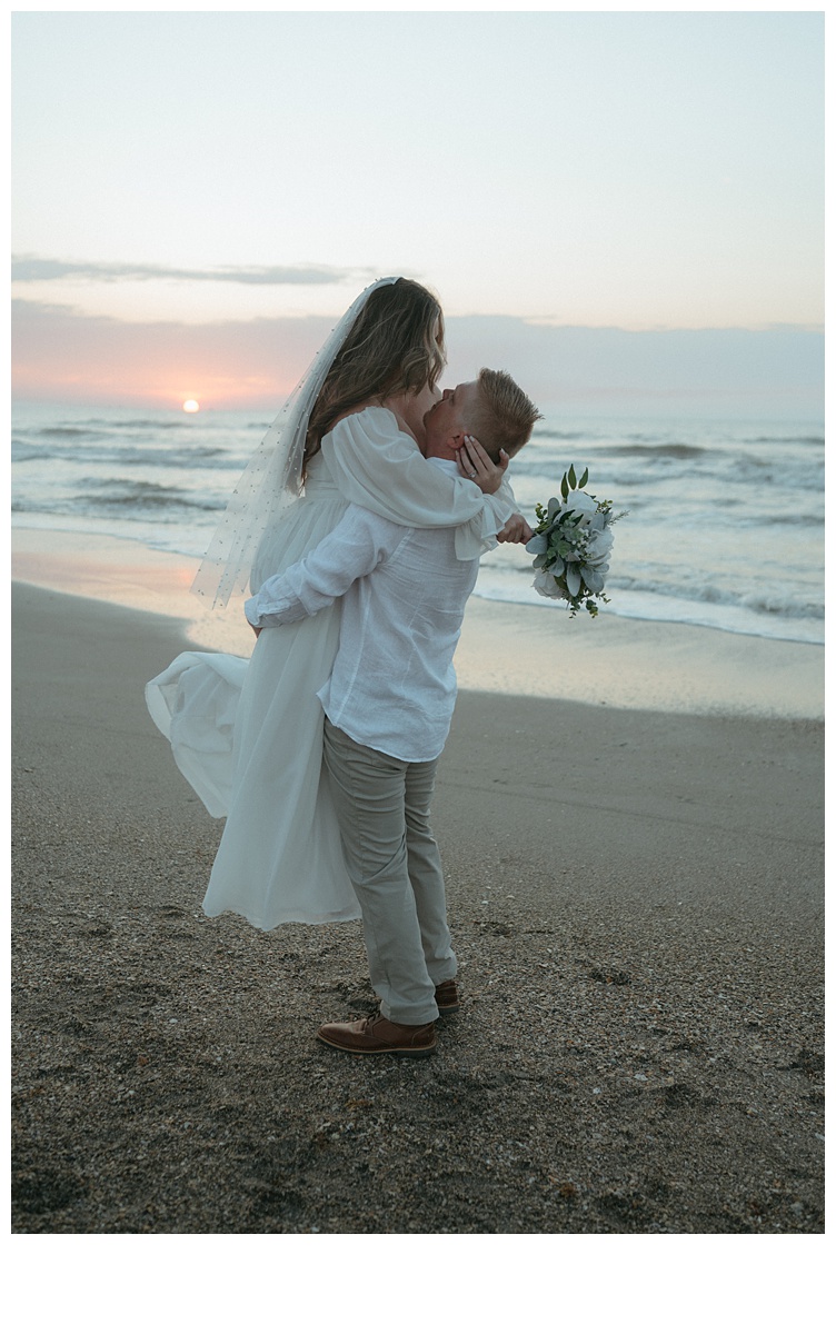 groom picks up bride at sunrise on beach