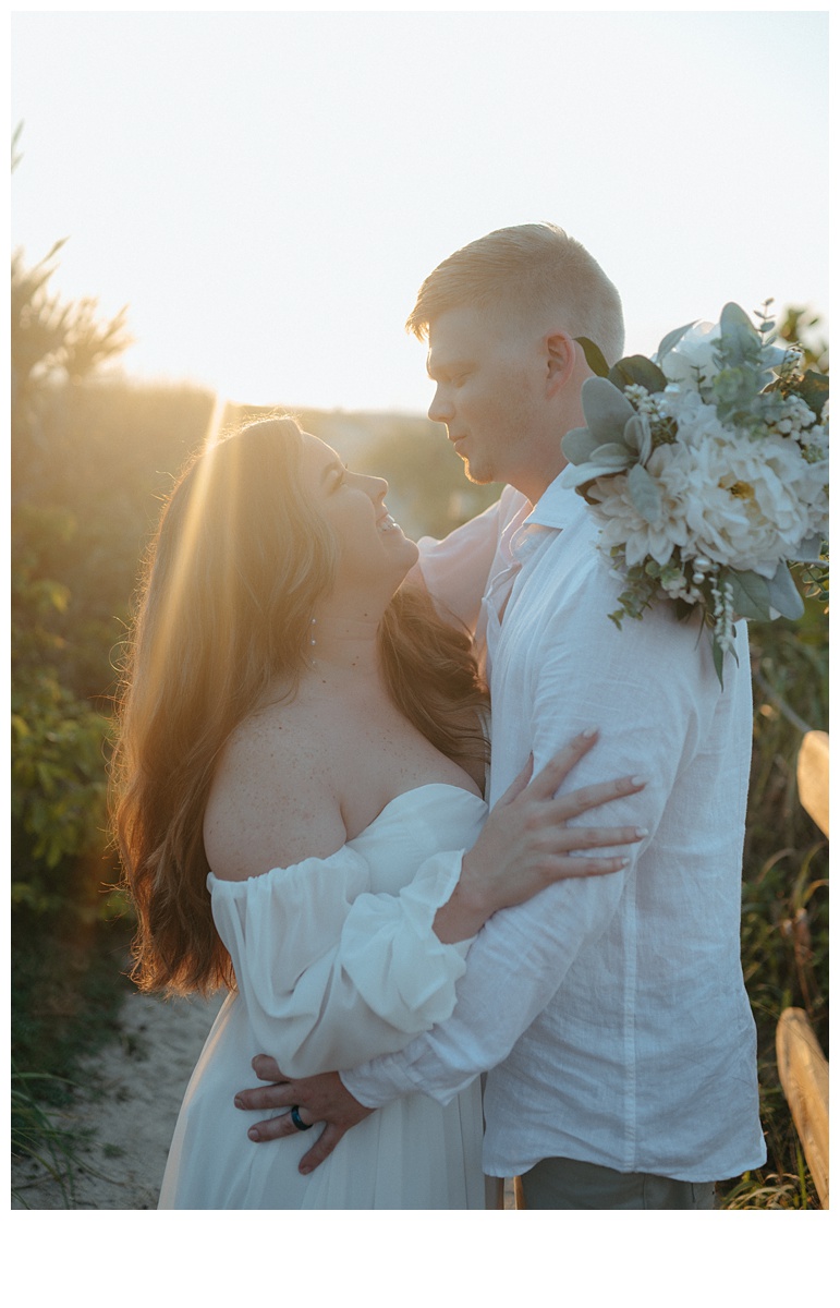 bride and groom smile at each other with golden huse of the sun in background