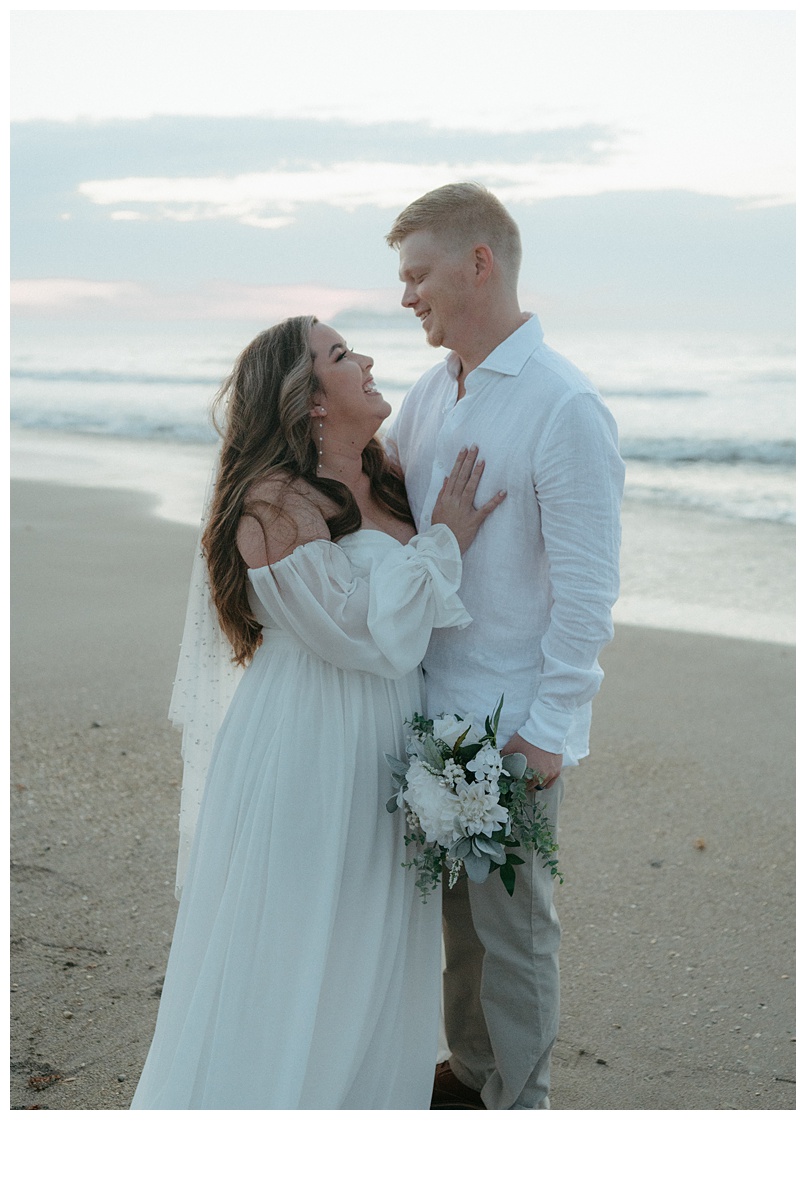 bride and groom intimate smiles on beach