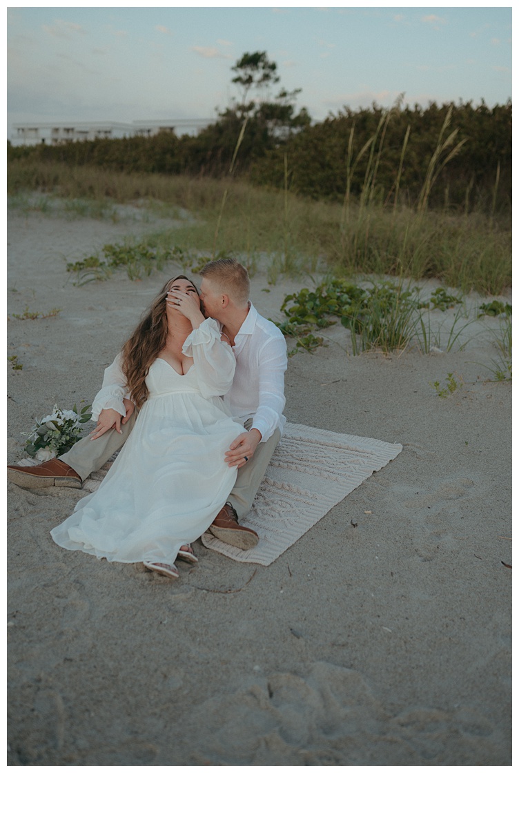 bride and groom laughing together at the beach