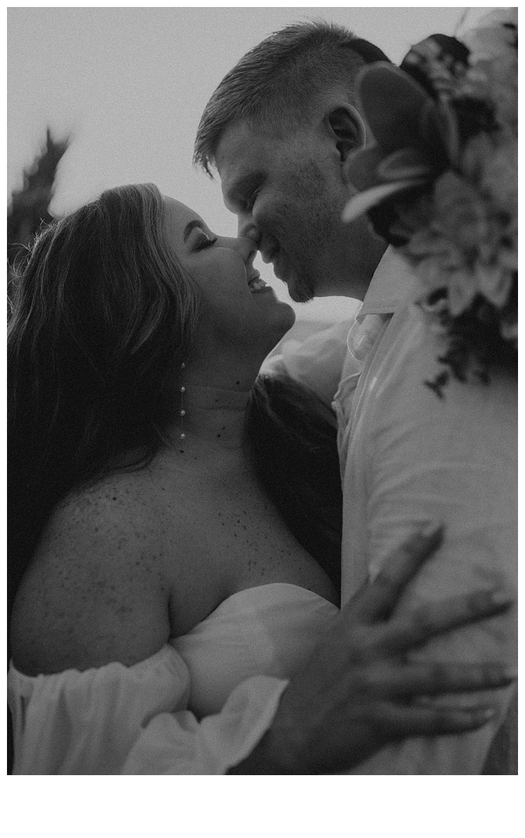 black and white romantic almost kiss between bride and groom