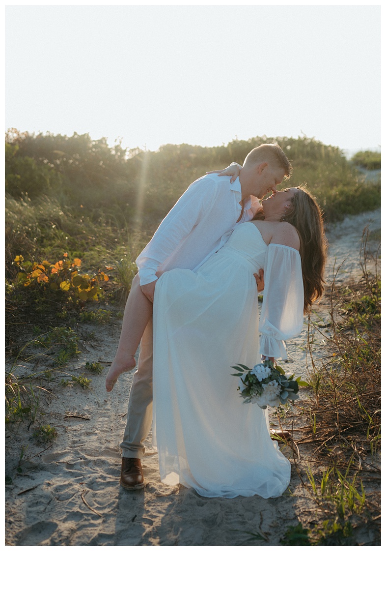 groom dipping bride on the beach after elopement