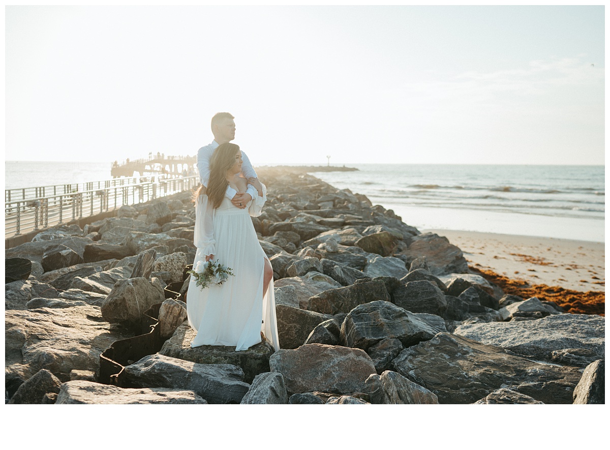 bride and groom posing on jetty park rocks after florida elopement