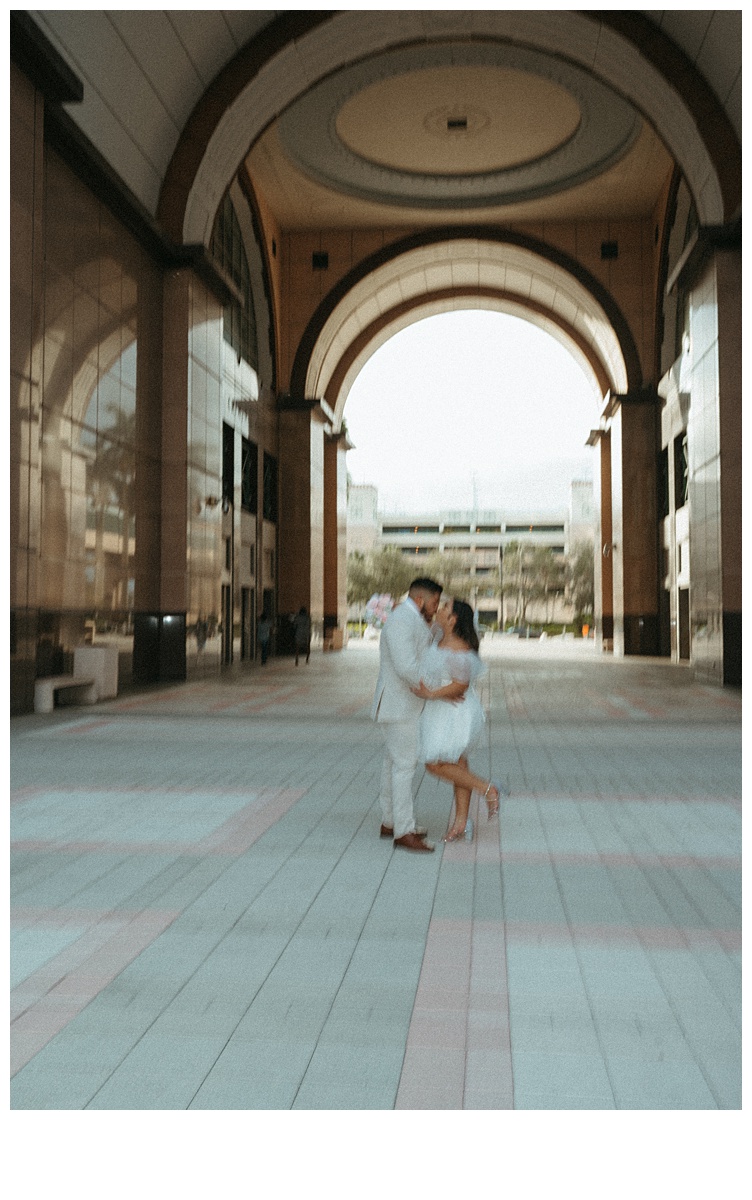 Couple kissing under courthouse arch