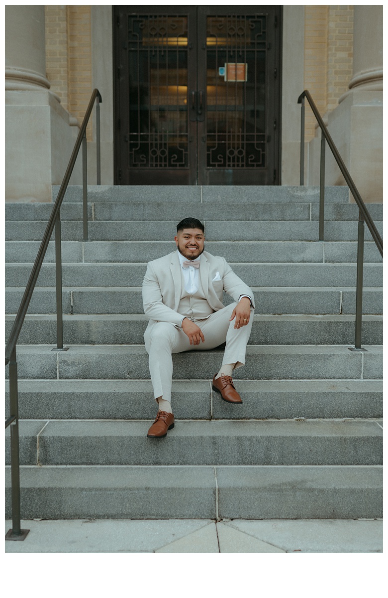 groom posing while sitting on steps of the palm beach courthouse