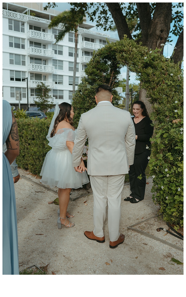 bride and groom during ceremony holding hands