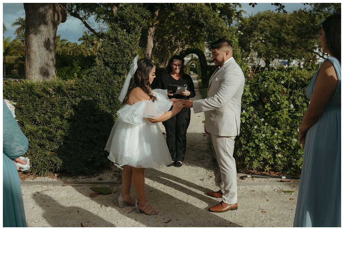 bride puts ring on groom during ceremony