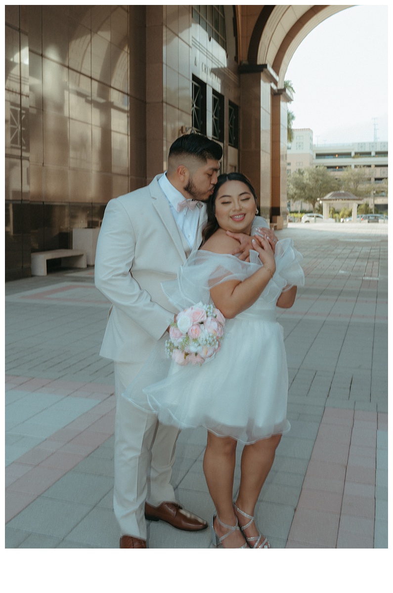 bride and groom sweet snuggle under courthouse arch