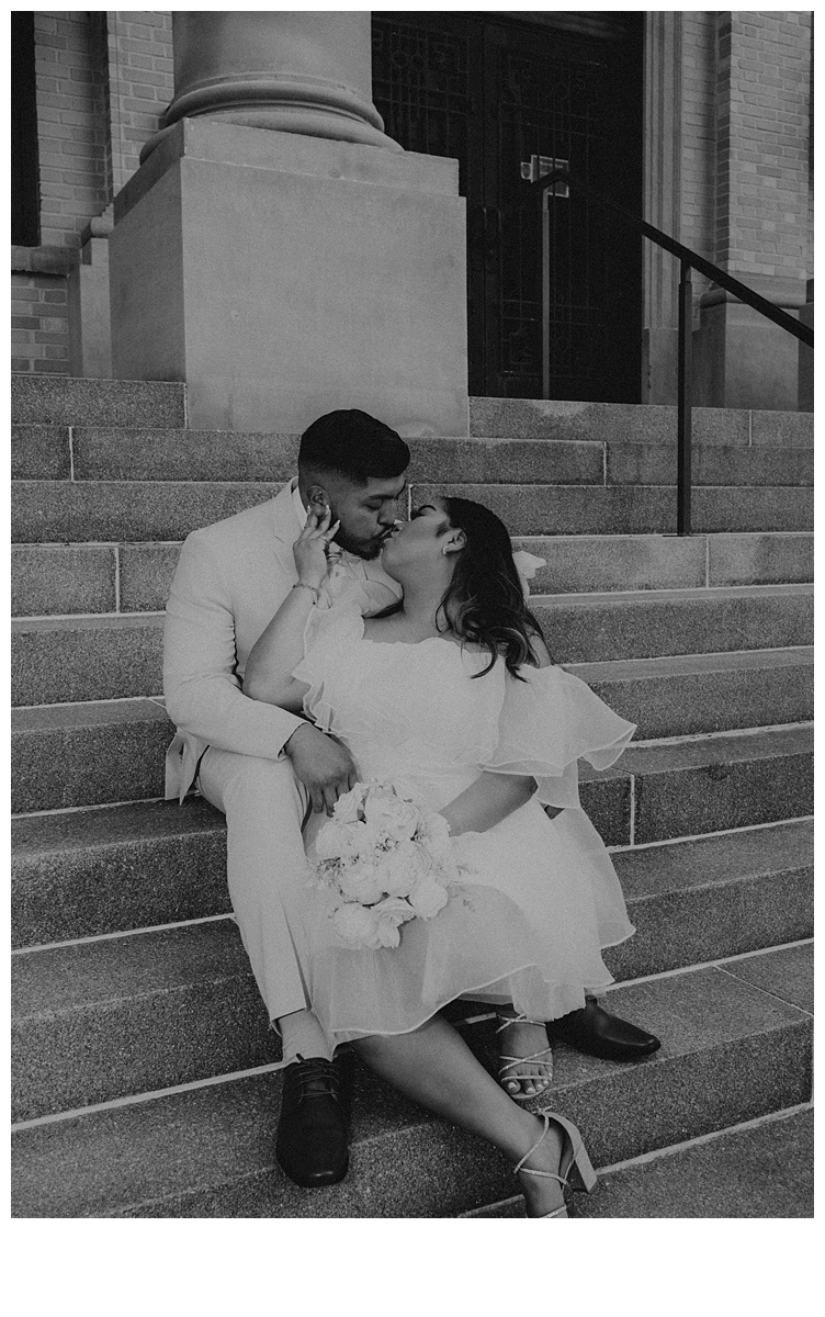 black and white bride and groom kissing on courthouse steps