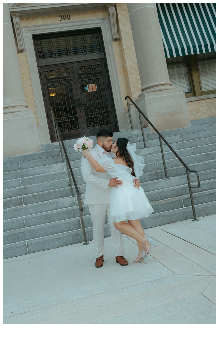 fun, slanted photo of bride and groom embracing with a kiss