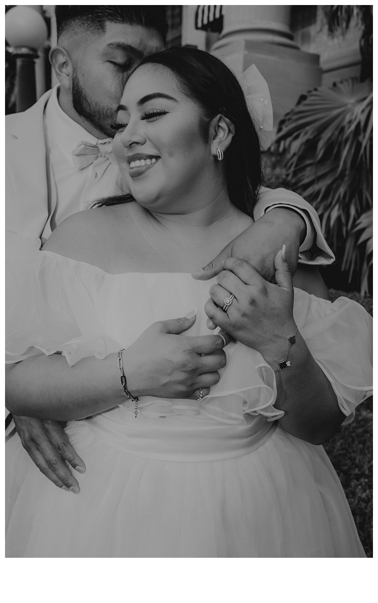 black and white bride smiles while being kissed on head by groom