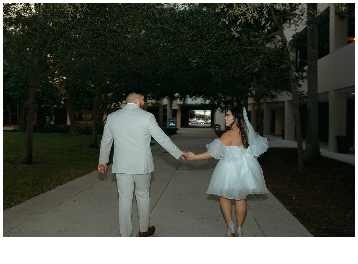 fun flash photo of bride and groom walking away through courtyard