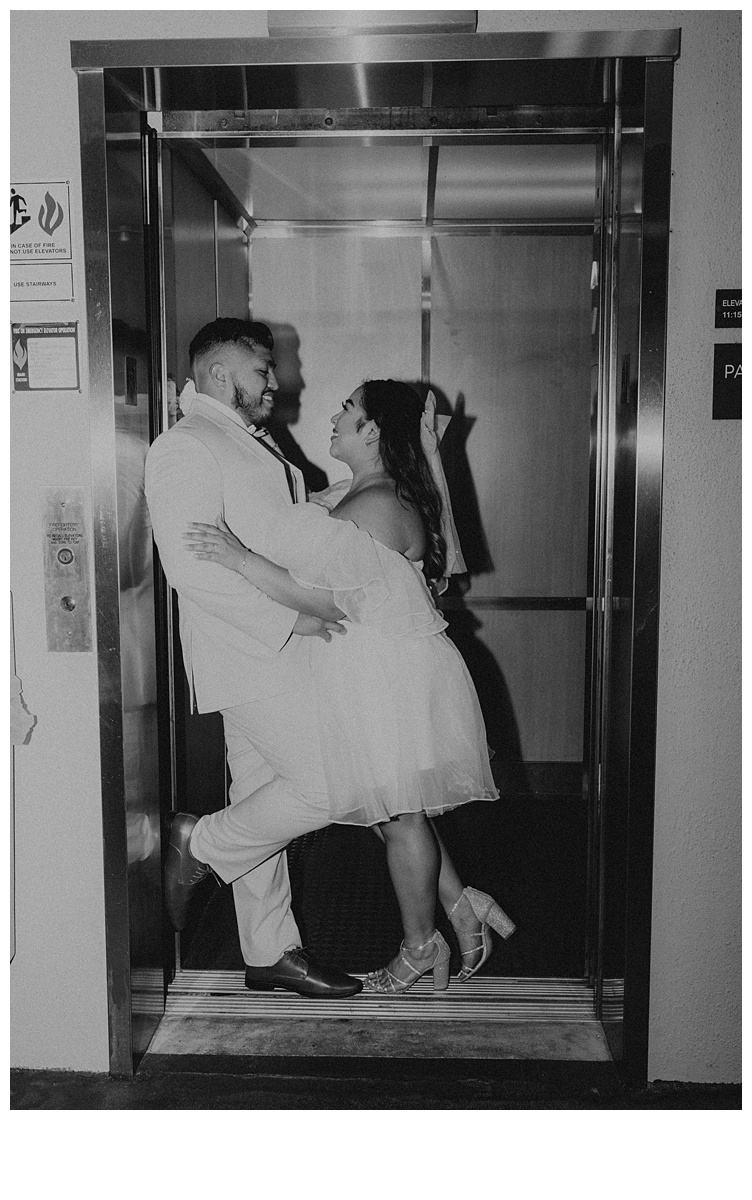 black and white fun and unique elevator photo of bride and groom