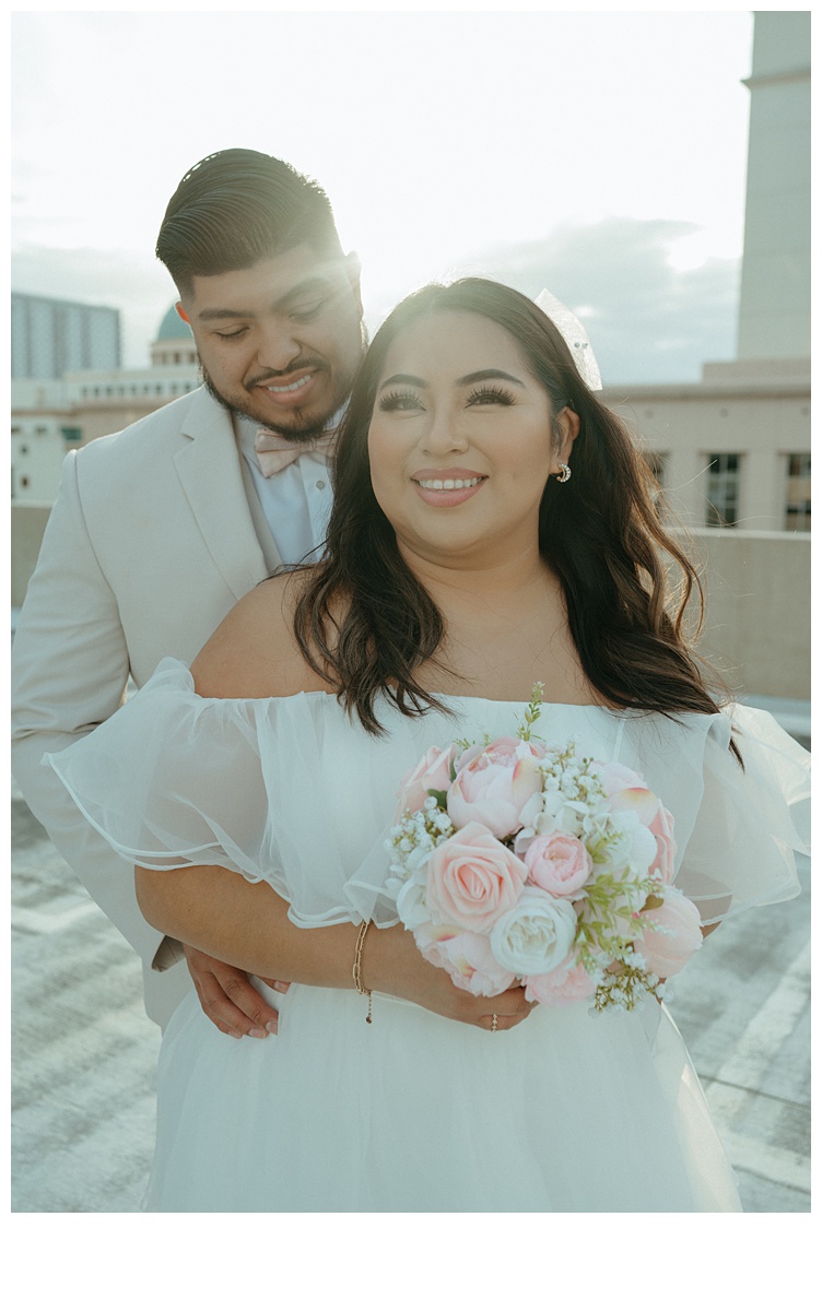 bride and groom standing close together on palm beach parking garage rooftop