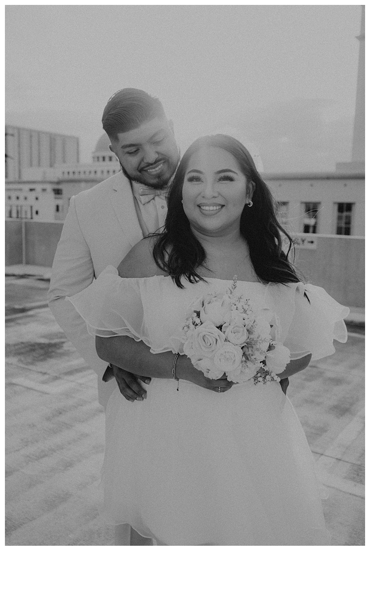 black and white bride and groom standing close together on palm beach parking garage rooftop