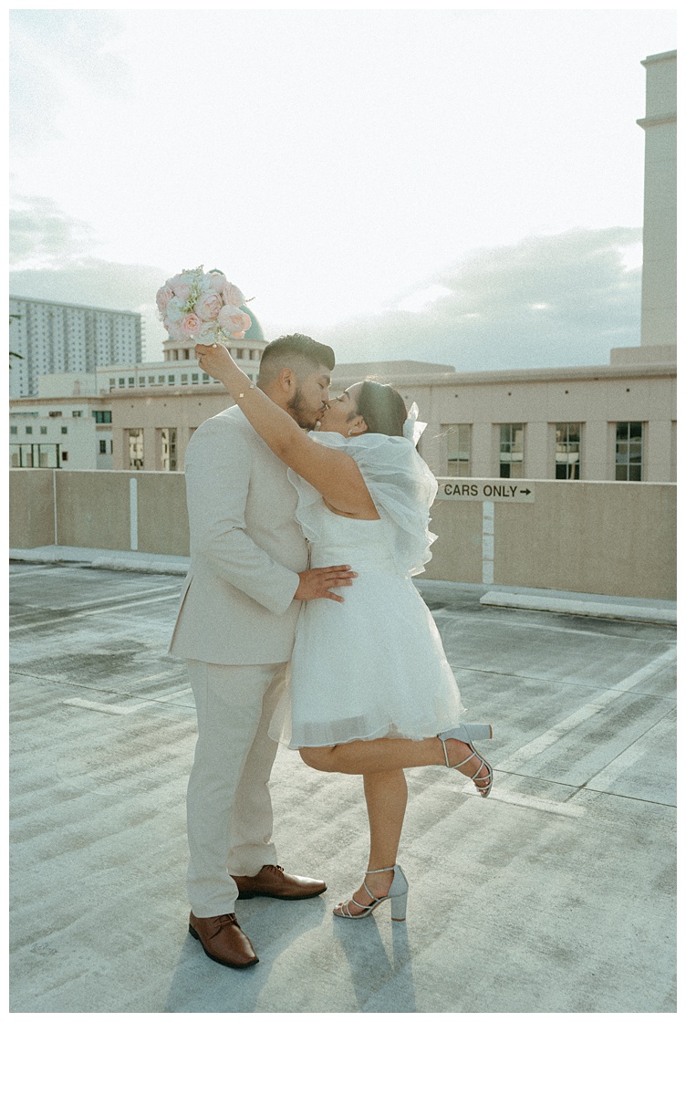 bride wraps her arms around groom for a kiss