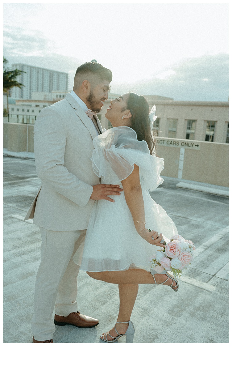 groom holding onto his bride for an almost kiss