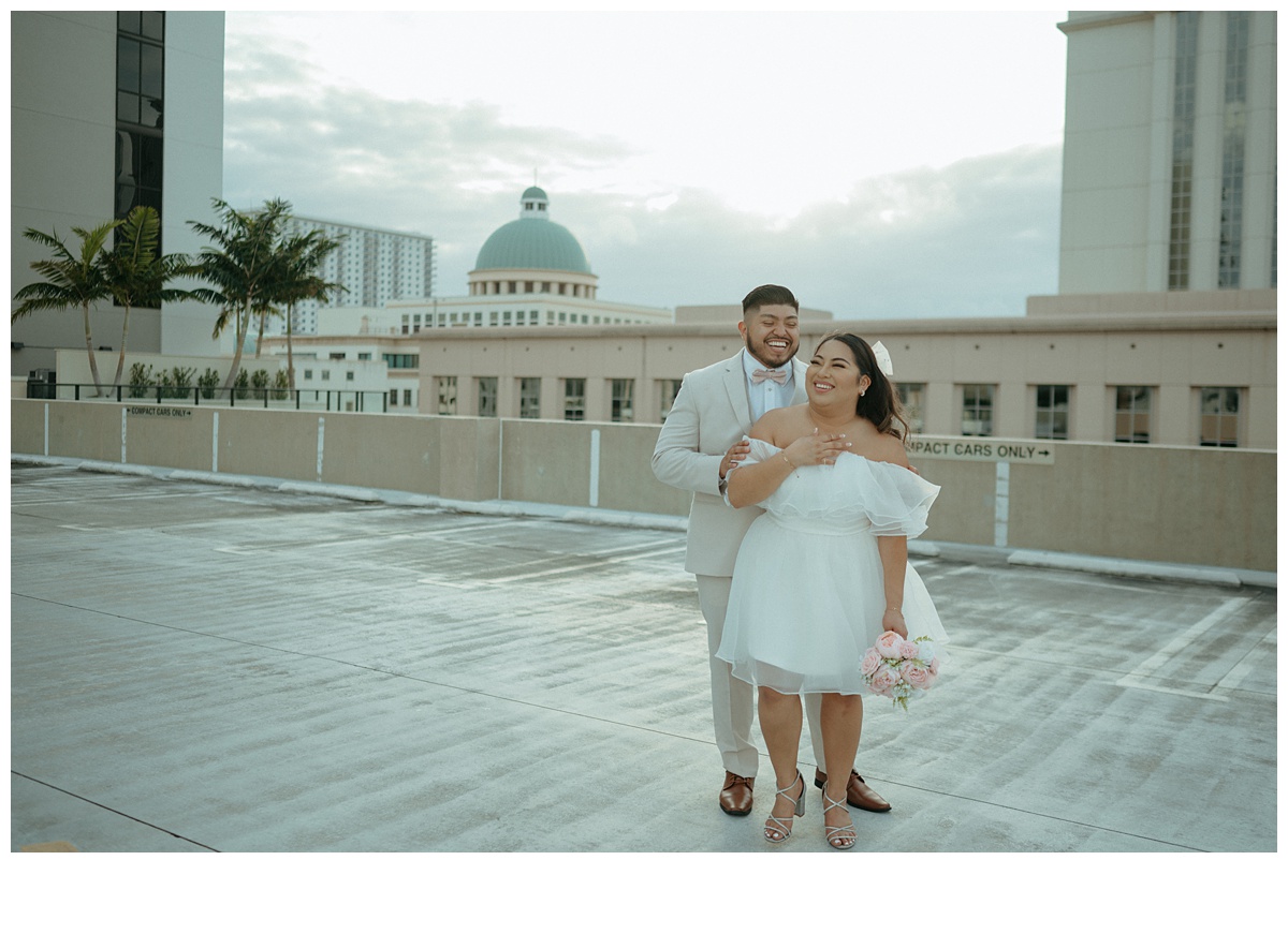 bride and groom laughing at grooms joke on parking garage rooftop