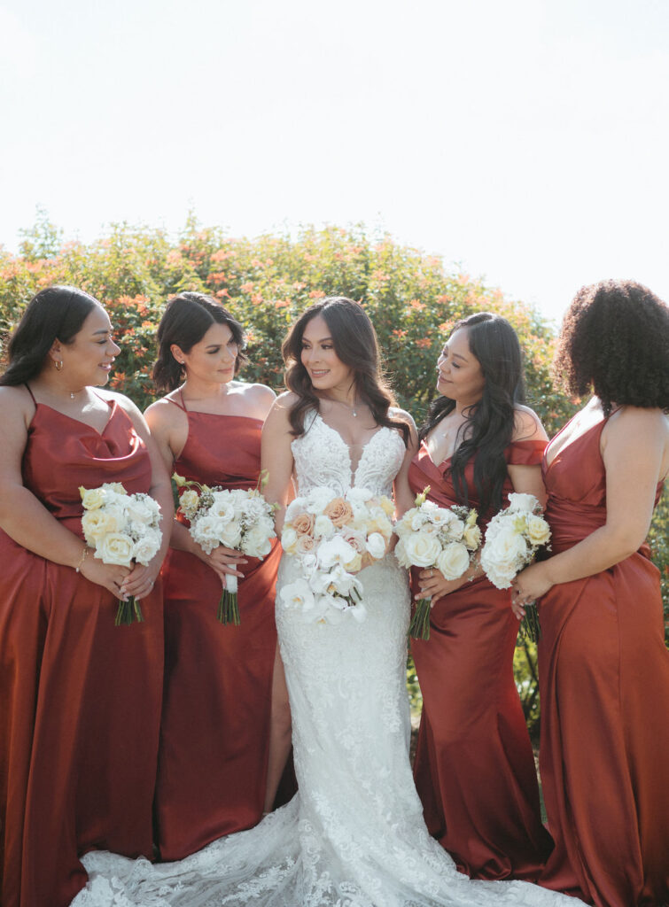 bride with her bridesmaids wearing red bridesmaid dresses